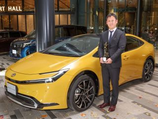 El ingeniero jefe del Prius, Satoki Oya, sostiene el trofeo de Coche del Año en Japón delante del nuevo Prius. 01 091223