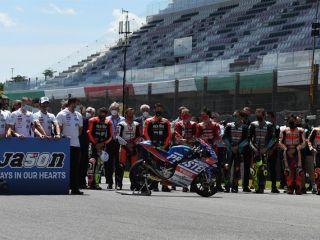 Los pilotos de MotoGP al frente de la formación de salida, han rendido un emotivo minuto de silencio como homenaje al suizo Jason Dupasquier, de 19 años, quien esta mañana falleció.