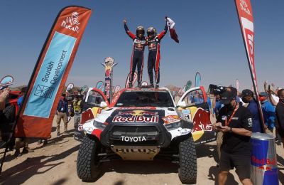 El piloto catarí Nasser Al Attiyah (d) y su copiloto Mathieu Baumel (i) del equipo Toyota Hilux celebran su victoria en la categoría de coches a su llegada a la meta de la duodécima etapa del Dakar de 680 kilómetros entre Bisha y Jeddah.