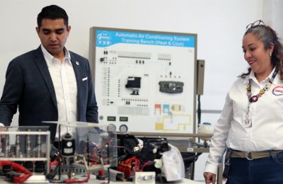 El rector de la Universidad Politécnica de Querétaro (UPQ), Carlos Antonio Contreras (i), y la coordinadora académica Enriqueta Ortíz (d) muestran autopartes al termino de una entrevista con EFE, el 14 de enero de 2023, en Querétaro (México). 01 160123
