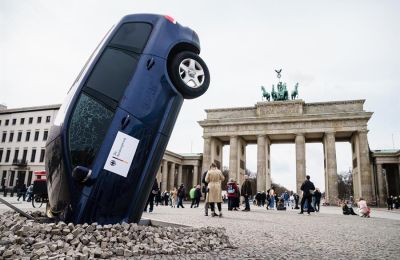 Una instalación de Greenpeace muestra un todocamino que se estrelló contra el suelo ante la Puerta de Brandenburgo, como parte de una protesta contra el bloqueo alemán a una eliminación europea de los motores de combustión, en Berlín. Alemania 01 230323