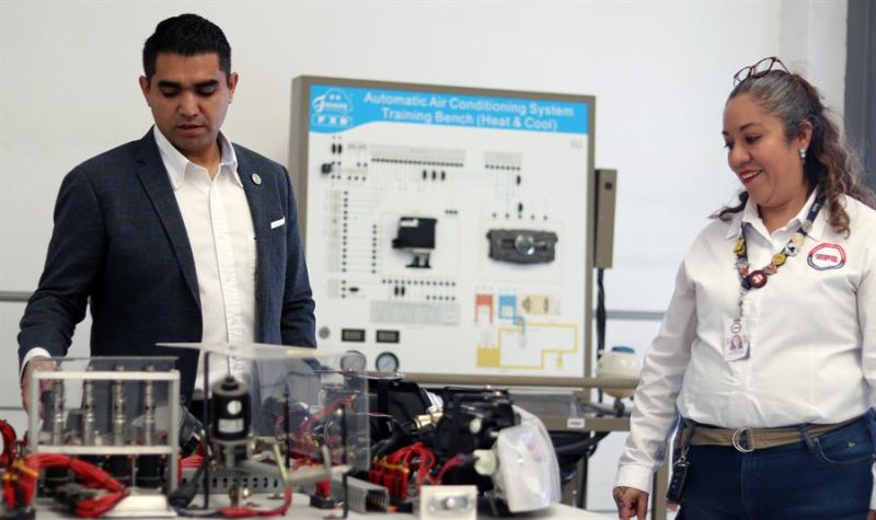 El rector de la Universidad Politécnica de Querétaro (UPQ), Carlos Antonio Contreras (i), y la coordinadora académica Enriqueta Ortíz (d) muestran autopartes al termino de una entrevista con EFE, el 14 de enero de 2023, en Querétaro (México). 01 160123