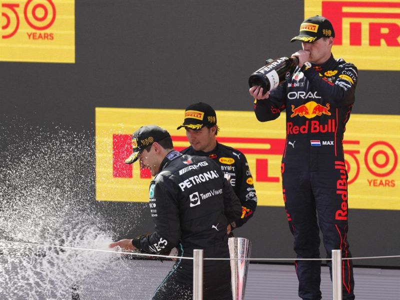El piloto de Red Bull Max Verstappen celebra su victoria en el Gran Premio de España de Fórmula Uno junto a su compañero de equipo, el mexicano Sergio Pérez (c), segundo clasificado, y el piloto británico de Mercedes George Russell (i). 01 220522